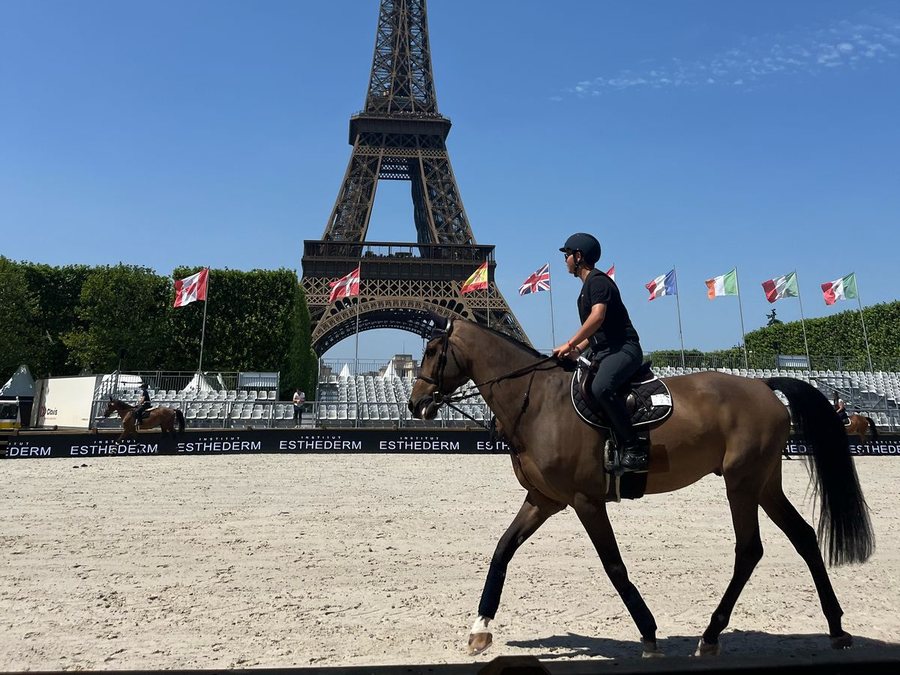 Peter G., an IWS student, riding in an arena in front of the Eiffel Tower